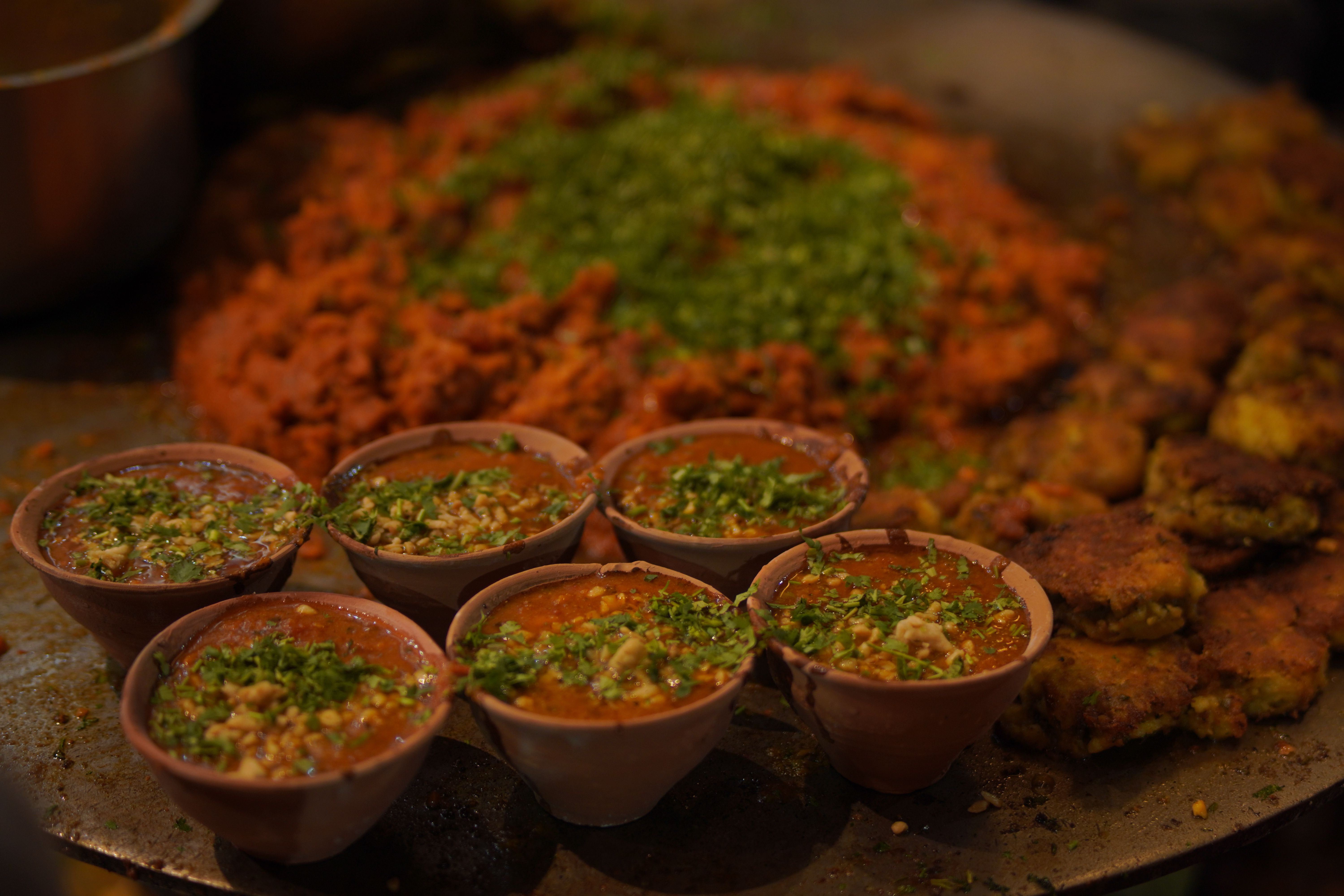 Close-up of Indian street food with vibrant toppings and spices served in clay pots